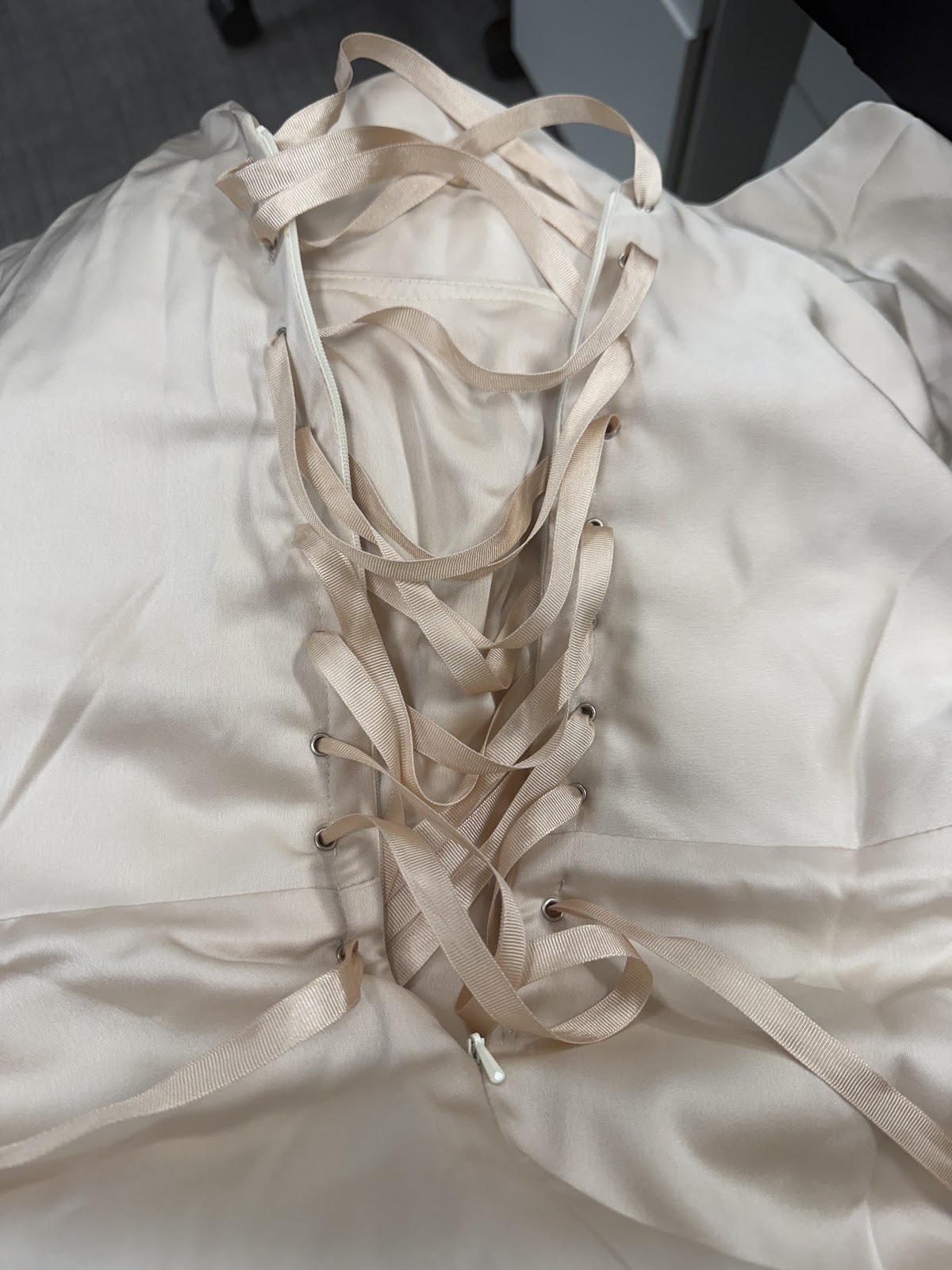 Ribbon lace-up corset back detail on a champagne satin bodice